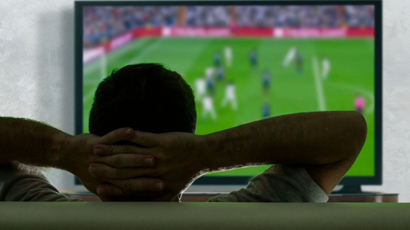 Uomo guarda una partita di calcio in tv